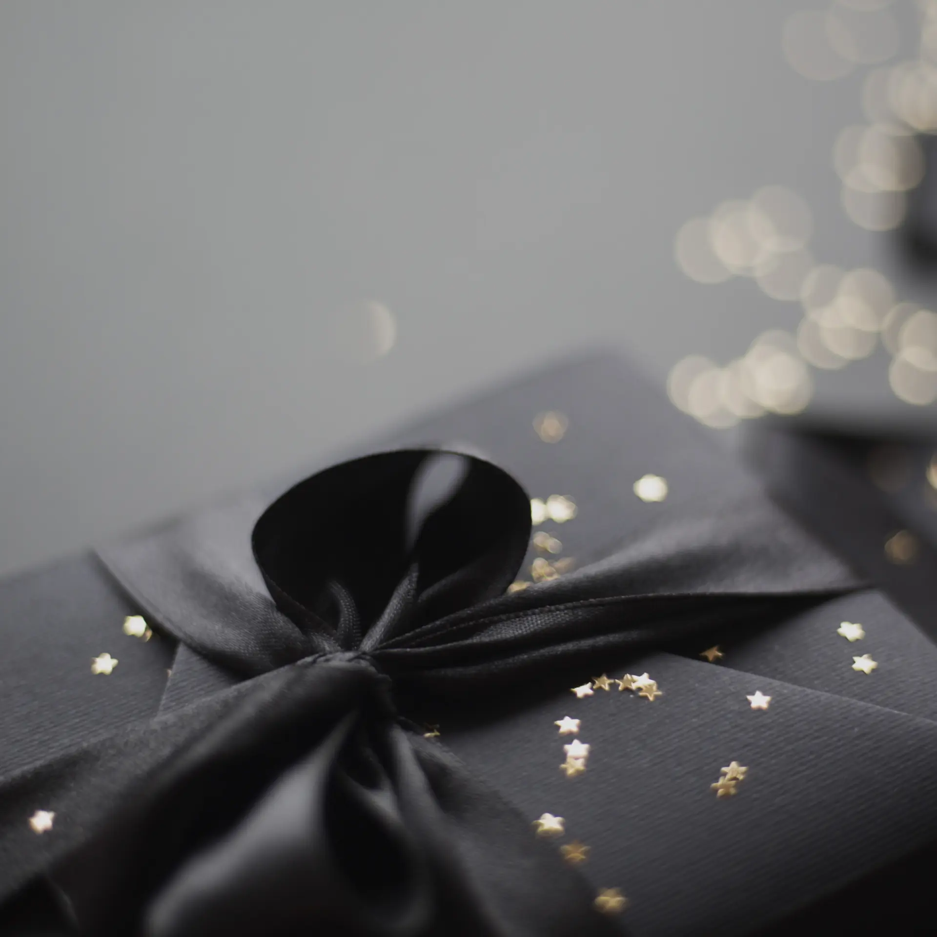 Gift box with black ribbon and gold stars